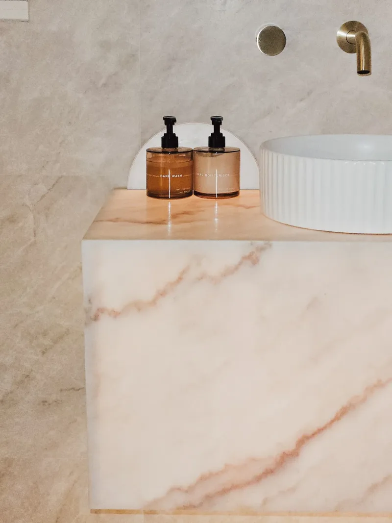 Custom stone vanity with vessel sink and brass tapware